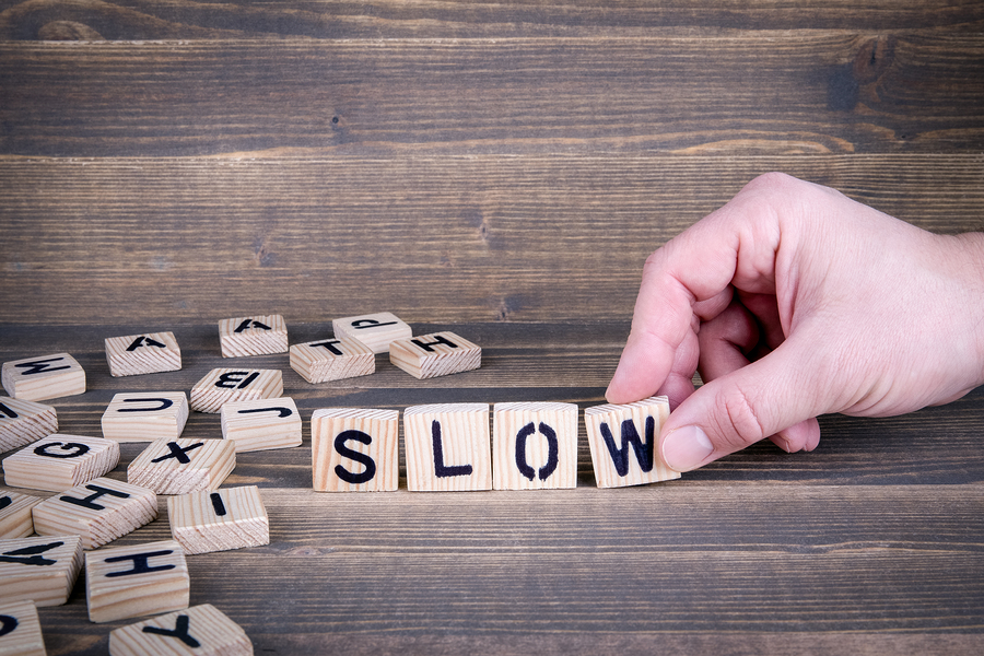 Slow. Wooden letters on the office desk, informative and communication background